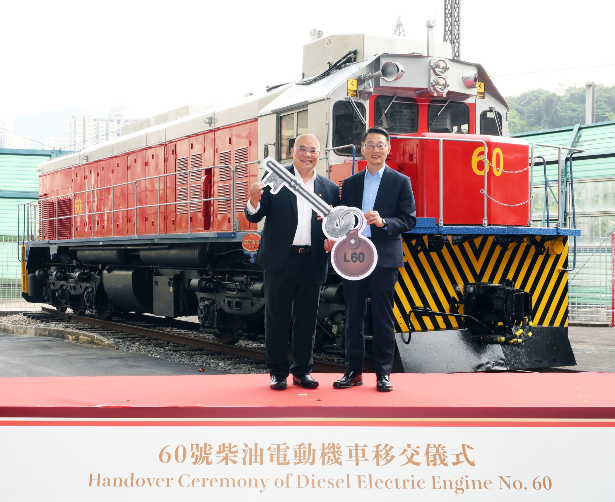 刘明光太平绅士（右）从李家润博士手上接过车匙，象征60号机车正式移交康乐及文化事务署香港铁路博物馆。